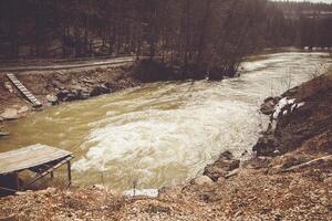 A River With A Wooden Dock In The Middle Of It photo