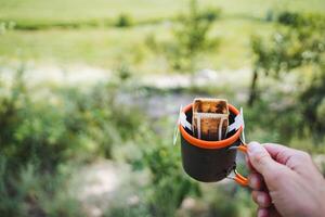 Transform your outdoor coffee routine with a convenient portable drip coffee maker amidst the beauty of nature, adding a touch of luxury to your wilderness relaxation photo