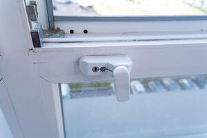 This is a closeup view of a window that features a lock on it, highlighting the details of the lock mechanism and the windows structure, showcasing its security aspects photo