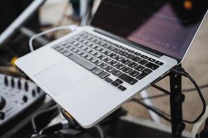 A laptop computer is currently positioned atop a microphone stand, showcasing an interesting setup for either a presentation or a recording session, blending technology and creativity photo