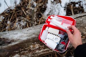 A prepared person confidently holds a stocked first aid kit, ready to assist anyone in urgent need during emergencies, highlighting the importance of being proactive and ready photo