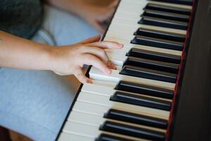 A person is playing a piano with their hand on the keys photo