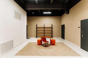 The room is furnished with a table, chairs, hardwood flooring, and a door, all inside a building typically used for events. It features a hall and a ceiling as key fixtures photo