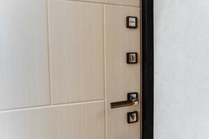 A detailed view of a door featuring a handle. The door is made of wood, possibly hardwood, with a rectangular shape. It appears to be a fixture on a cabinetry, possibly a home door photo