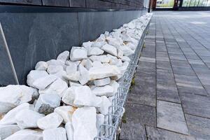 Beside the building, a decorative line of white rocks adorns the brick sidewalk, creating a visually appealing blend of textures and elements that enhance the areas aesthetic charm photo