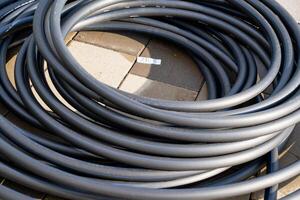 A large collection of various wires and cables are organized and stacked on top of each other on a table, creating an intriguing display of electrical wiring components and supplies photo