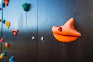 This is a detailed closeup image of a vibrant climbing wall that features an interesting duck face design prominently displayed on it, likely catching the attention of many passersby photo