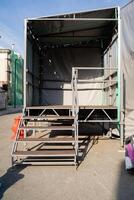 In a spacious parking lot, there is a trailer that features a set of stairs leading up to its entrance, making it accessible for individuals to enter and exit comfortably photo