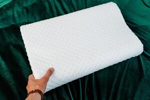 The bed features a white cushion surrounded by green fabrics, gestures, thumbs, sports clothes, grass, and patterns, creating a vibrant and dynamic atmosphere in the room photo