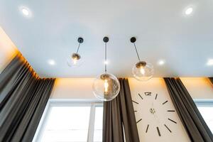 In a charming room with a vintage clock elegantly positioned on the wall, you can also find beautiful curtains gracefully hanging down from the ceiling, adding to the overall ambiance photo