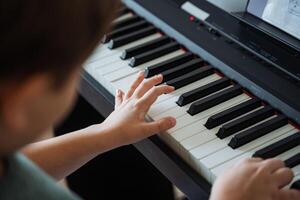 A person is skillfully playing a piano, with their hands actively dancing across the keys, producing beautiful music as they express themselves through this wonderful instrument photo