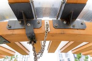 This is a detailed closeup view of a unique metal and wood structure, showcasing the intricate features of its attached chain and brackets photo