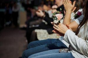 Individuals seated in a row clapping hands in unison photo