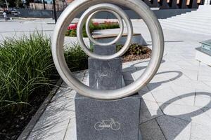 The sculpture features two circular shapes, one showcasing a bicycle icon, blending artistic creativity with cyclinginspired elements in a seamless and harmonious design photo