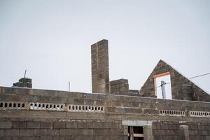 A new building is currently being constructed using bricks along with chimneys as essential features of the architectural design, emphasizing overall aesthetic and functionality photo
