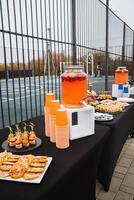 An elegantly arranged table showcases a vibrant assortment of delectable food items and refreshing drinks, creating a delightful feast that is pleasing both to the eyes and the palate photo