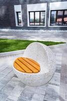 Within the park, there is a stone chair with a wooden seat, creating a peaceful oasis for visitors to unwind in the midst of nature, away from the busy rhythm of daily life photo