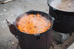 A pot filled with fresh, vibrant carrots is currently being cooked in boiling water on the stove, ensuring that they will be perfectly prepared for a delicious and healthy dish to enjoy photo