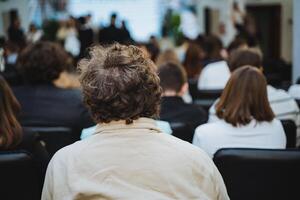 Man sharing in front of audience at event in crowded room photo