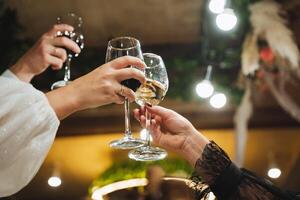 At a lively party, two individuals enthusiastically raise their wine glasses to toast each other, celebrating good times and camaraderie. Their gestures signify joy and connection photo