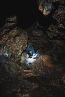Immerse yourself in an adventurous caving exploration through a captivating and dark underground cave environment that awaits you photo