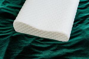 A white pillow is placed on a green blanket, forming a cozy and relaxing space. It emits comfort and tranquility, providing a soothing place to unwind and rest peacefully photo