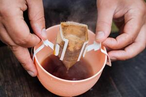 Learn how to make pour over coffee using a portable drip bag filter, a convenient way to enjoy a caffeine boost while outdoors. Perfect for relaxation and avoiding messy hands photo