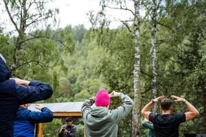 A group of individuals exercising in a scenic forest, fostering bonds, prioritizing fitness, and appreciating nature. Its a joyful and green experience of community and wellness photo