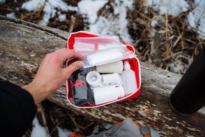 A person is confidently holding a first aid kit in their hand, ready to assist anyone in need of medical attention during an emergency or unexpected situation at any moment photo