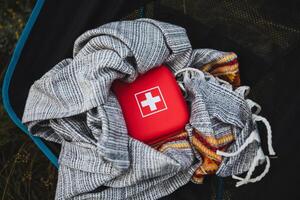 A compact first aid kit securely wrapped in a blanket, designed specifically for outdoor adventures and effective emergency preparedness photo