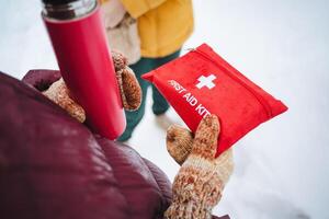 A person is holding a compact and wellequipped first aid kit securely in their hand, indicating preparedness for emergencies and health situations that may arise unexpectedly photo