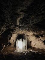 Deep within the earth lies a fascinating cave, where a bright light shines brilliantly at its center, illuminating the dark surroundings and creating an enchanting, mystical atmosphere photo