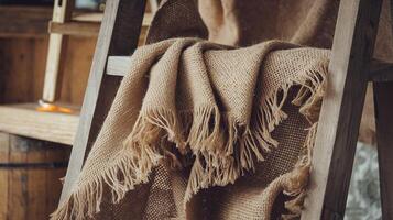 Rustic Burlap Fabric Drape on Wooden Ladder with Warm Brown Toned Background in Cozy Setting photo