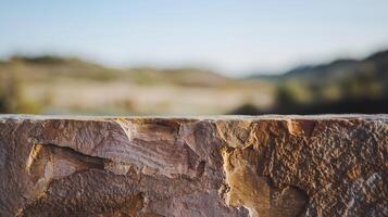 Rough Textured Stone Surface with Blurred Natural Landscape in Soft Sunlight and Blue Sky Background photo