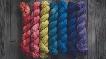 Colorful Yarn Skeins Arranged in a Rainbow Pattern on Rustic Wooden Background for Crafting Projects photo