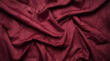 Wrinkled Maroon Fabric with Geometric Patterns on Dark Textured Background for Textiles and Design photo