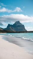 Majestic Mountain with Cloudy Peak Overlooking White Sandy Beach and Turquoise Ocean on Clear Day photo