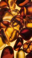 Closeup of Polished Amber Stones in Rich Golden and Deep Red Hues Illuminated with Soft Light photo