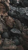 Closeup of Natural Volcanic Rocks with Textured Surfaces on Dark Rocky Shoreline in Soft Lighting photo