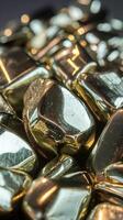 Closeup of Shiny Polished Gold Nuggets in Metallic Finish with Reflective Surface in Soft Light photo