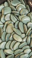 Polished Light Green Stones with Smooth Finish and Natural Patterns on Black Background for Decoration photo