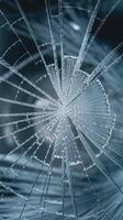Closeup of Circular Shattered Glass Pattern Reflecting Light on Dark Background for Metaphors of Fragility photo