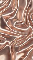 Shiny Rose Gold Metallic Silk Fabric Texture with Smooth Luxurious Flowing Waves Background photo