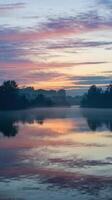 Serene Sunrise Over Calm Lake with Colorful Reflections and Misty Trees in Peaceful Nature Landscape photo