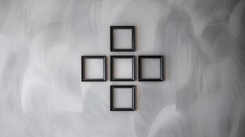 Minimalist Black Square Frames Arranged in Geometric Pattern on Neutral Gray Textured Wall Background photo