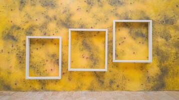 Three White Empty Frames Against Yellow Textured Artistic Wall with Abstract Pattern and Tile Floor photo