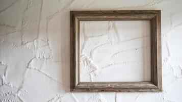 Rustic Wooden Picture Frame On White Textured Stucco Wall in Minimalist Interior Design Setting photo