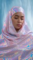 Serene Woman in Shimmering Iridescent Hijab with Soft Blue Draped Background photo