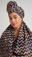 Woman Wearing Blue and Beige Zigzag Patterned Headwrap and Matching Shawl With Neutral Background photo