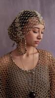 Woman Wearing Intricate Beaded Headpiece and Net Clothing Against Soft Purple Background photo